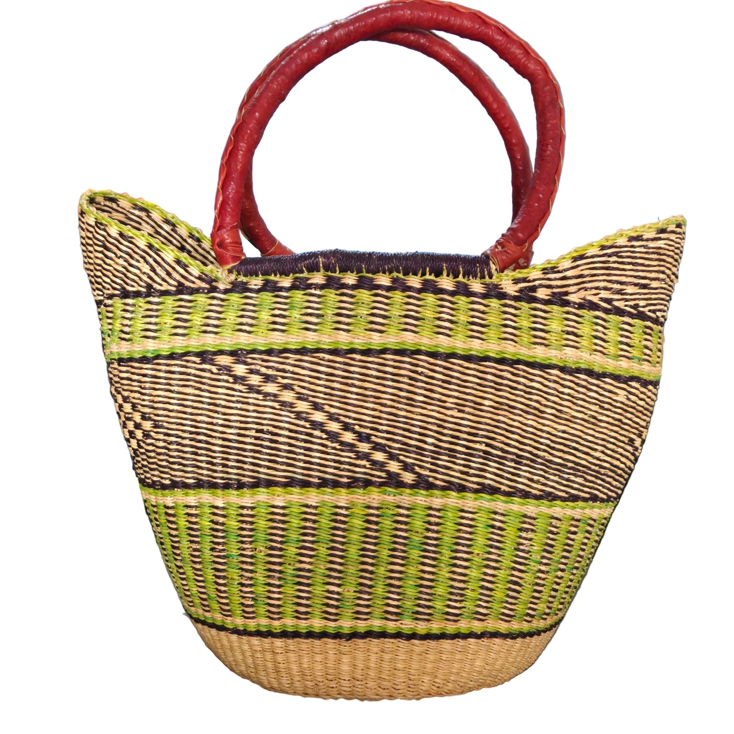 A woven straw tote bag with dark brown and lime green geometric stripes and thick red handles, photographed in a cluttered indoor setting.