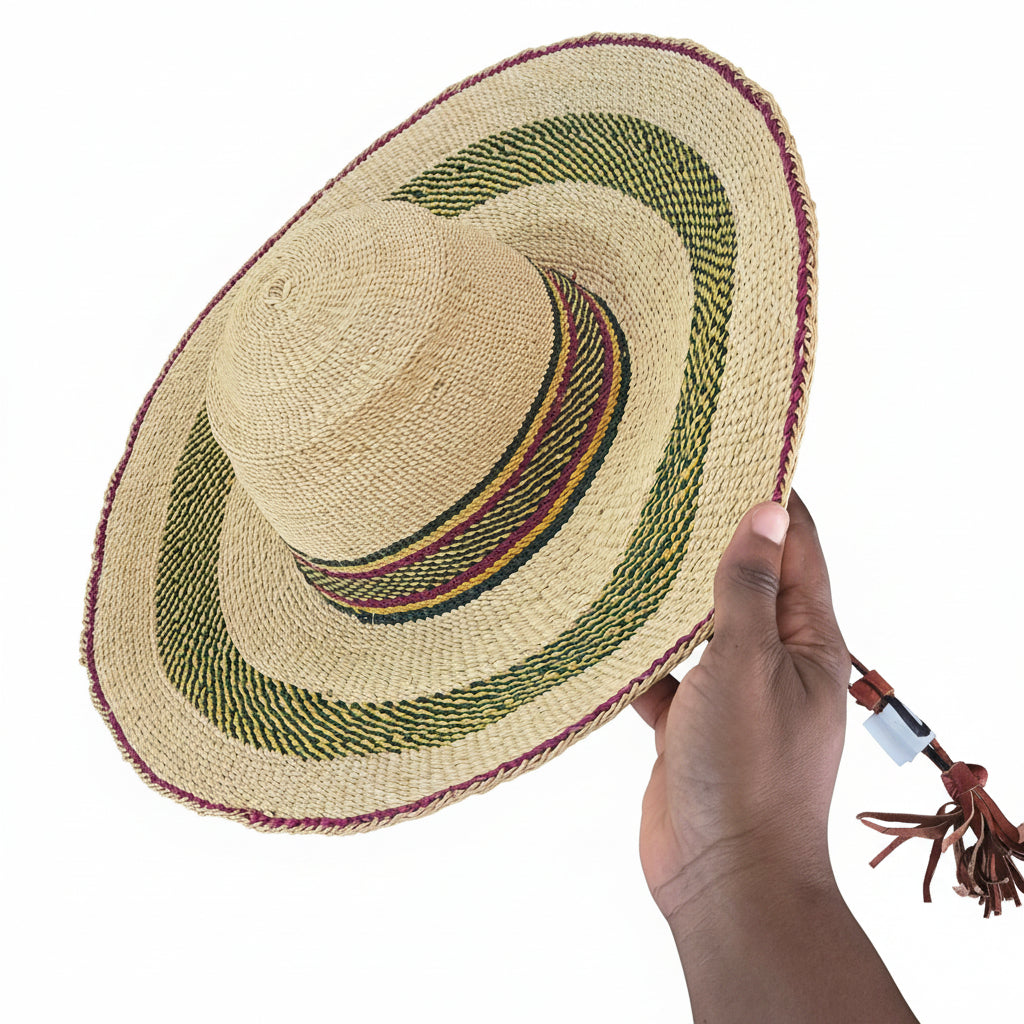 Hand holding a woven straw hat with a decorative band on a textured surface