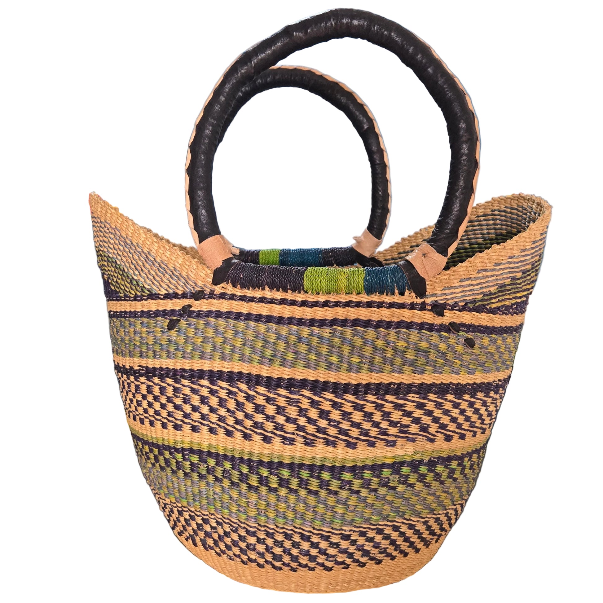 A hand-woven basket bag with dark brown twisted handles, featuring vertical stripes of black, beige, and olive green on a woven body, photographed on a desk.