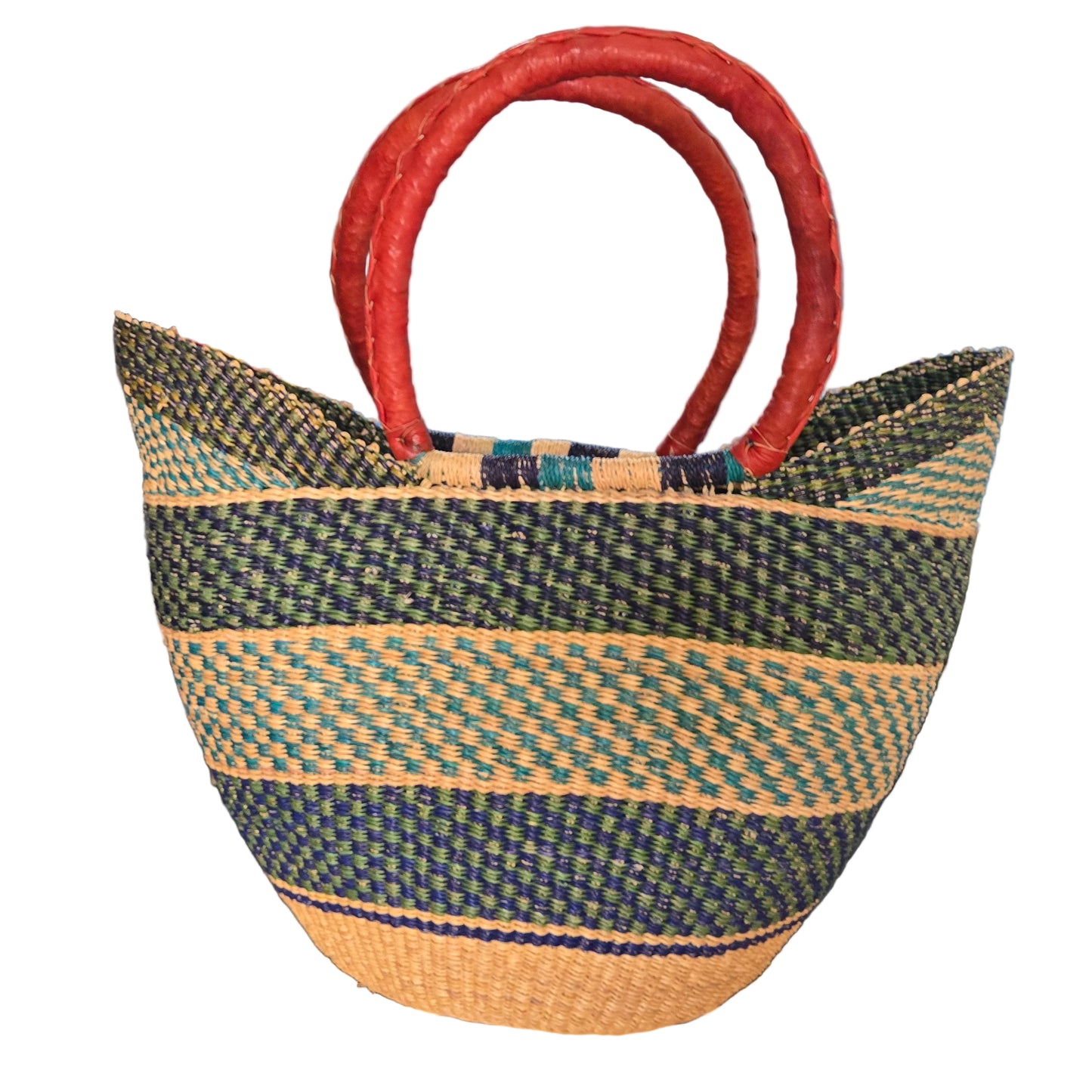 A woven straw tote bag with dark green and beige stripes and thick red handles, photographed on a desk with office items in the background.