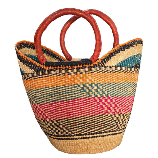 A woven straw tote bag with vertical stripes in black, orange, pink, teal, and beige, featuring two thick, reddish-brown handles.