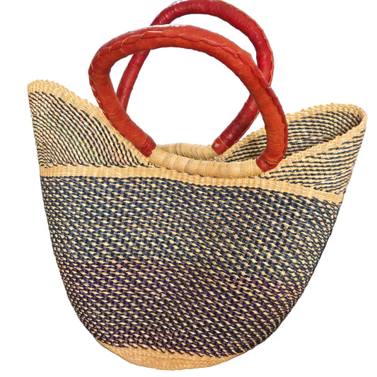 A woven straw tote bag with a black and beige patterned body and two curved reddish-brown leather handles.
