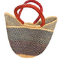 A woven straw tote bag with a black and beige patterned body and two curved reddish-brown leather handles.